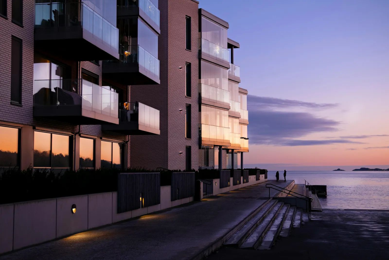 Modern fastighetsbyggnad vid havet i solnedgång – Single Pane of Glass teknologi
