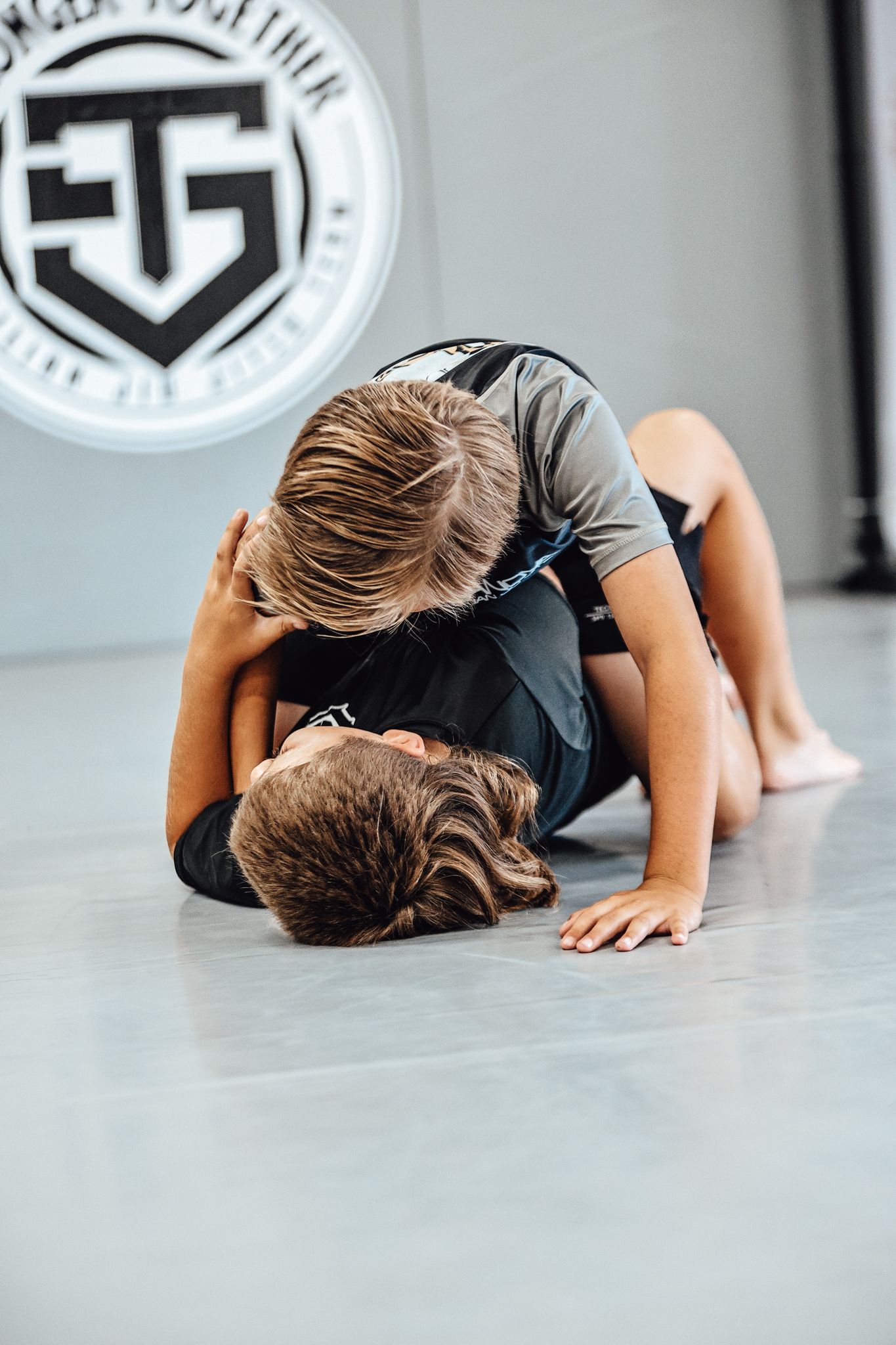 Two kids practicing full mount escape drill during BJJ field trip