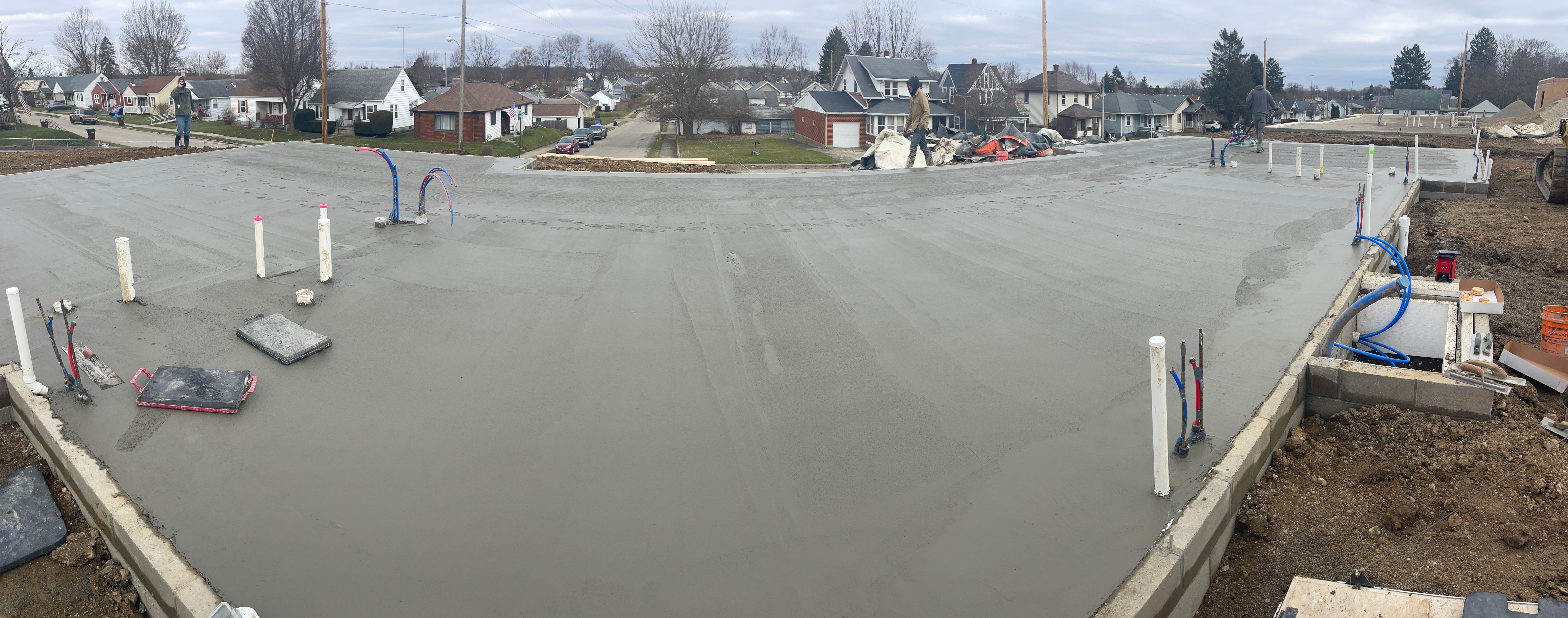 Concrete foundation slab with plumbing stubs and crew on site in Columbus Ohio