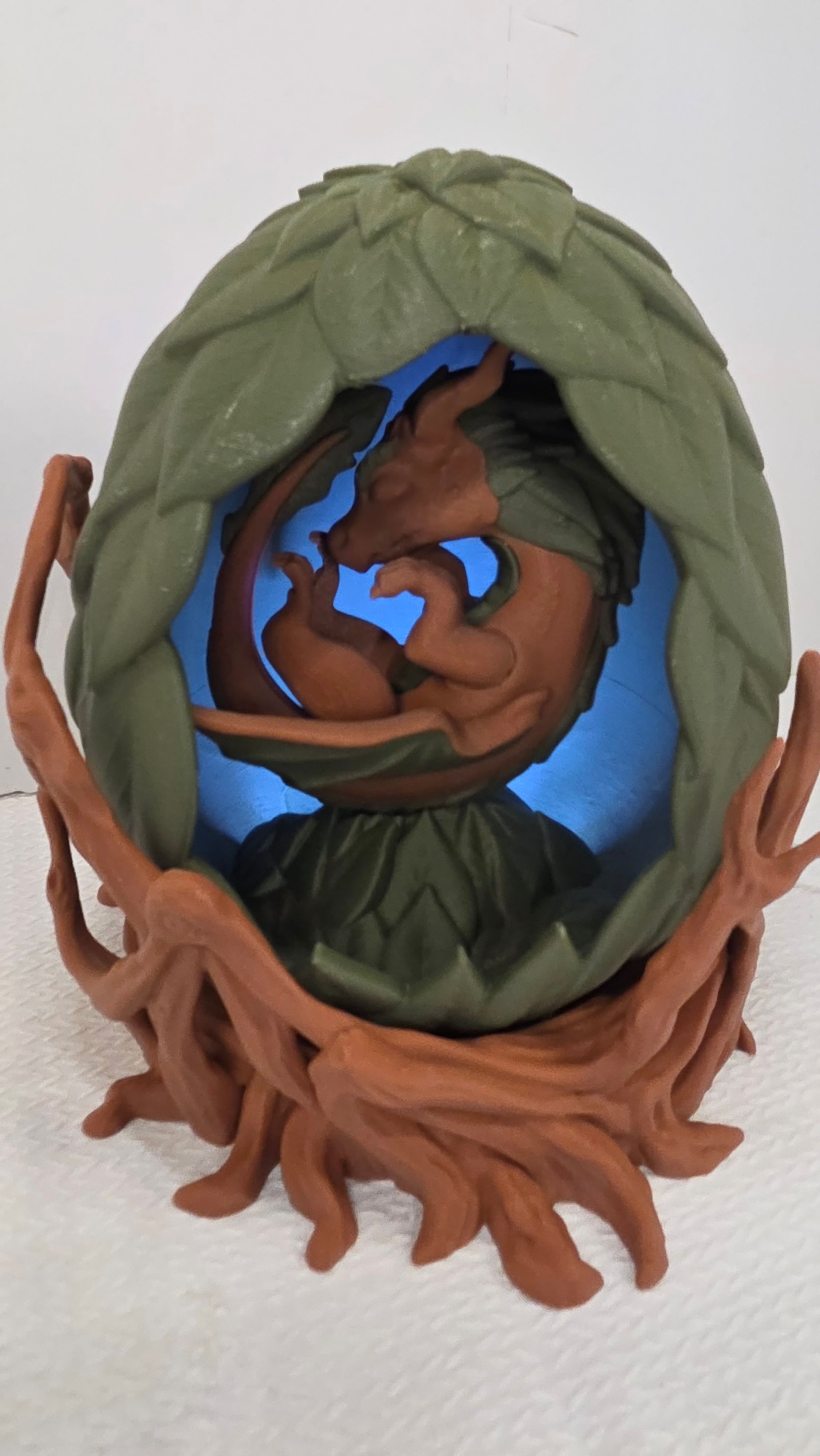 Brown dragon sleeping in green leaf egg with LED light